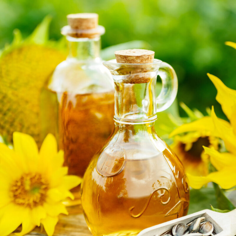 Sunflower oil with seeds Closeup photo of sunflower oil with seeds on wooden background in the garden